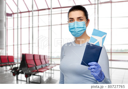 young woman in mask with air ticket and passport 80727765