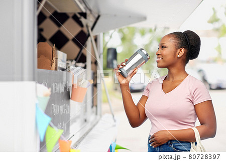 woman with tumbler and food in string bag 80728397