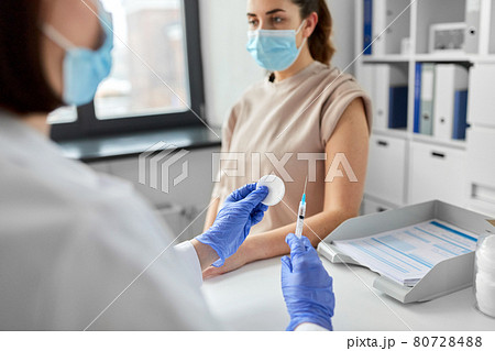 female doctor with syringe vaccinating patient female doctor with syringe vaccinating patient 80728488