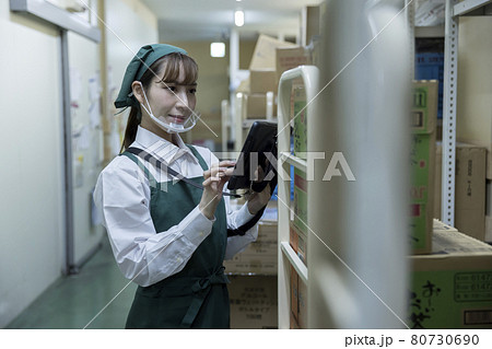 スーパーのバックヤードでで在庫管理をするマウスシールドをした女性従業員 スーパーのバックヤードでで在庫管理をするマウスシールドをした女性従業員 80730690
