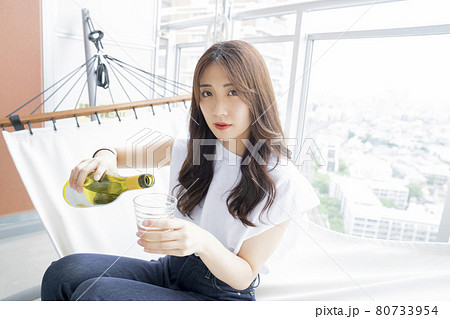 ハンモックでお酒を飲む女性 80733954