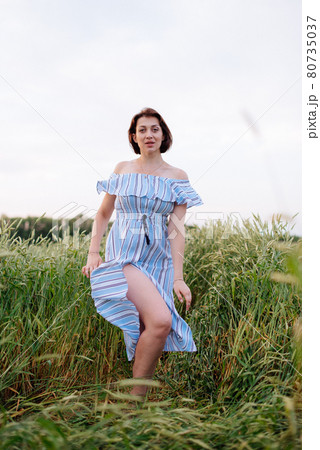 Beautiful young woman in summer in a wheat field 80735037