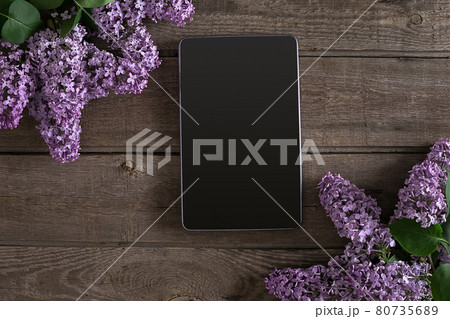 Lilac blossom on rustic wooden background, tablet with empty space for greeting message. Top view Lilac blossom on rustic wooden background, tablet with empty space for greeting message. Top view 80735689