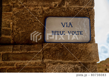Colle di Val D'elsa, Siena, Tuscany, Italy. The vaulted street is a picturesque covered alley, a medieval passage in the old town. The street plaque. 80736083