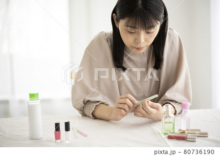 窓辺で爪やすりで爪のお手入れをする女性 窓辺で爪やすりで爪のお手入れをする女性 80736190