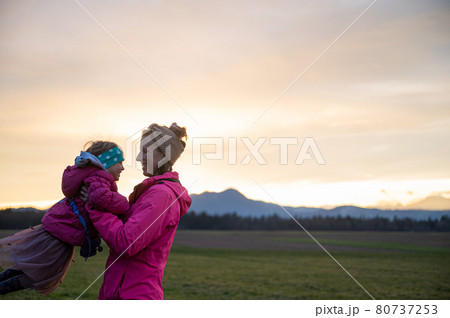 Happy young mother having fun with her toddler daughter outside in a meadow 80737253