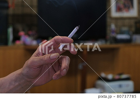 タバコを持つ男性の手元　喫煙者　煙草を部屋で吸うイメージ写真素材 80737785
