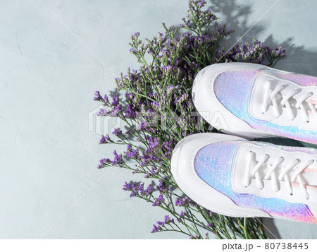 White sneakers with sequins and purple flowers on turquoise background White sneakers with sequins and purple flowers on turquoise background 80738445