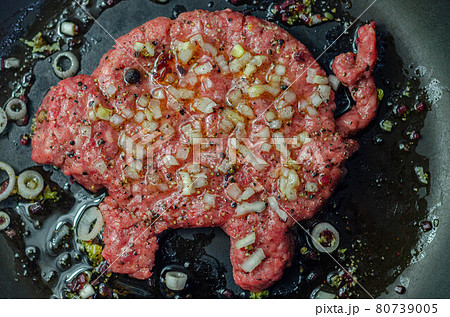 Minced meat with fresh spring onions and spices in the shape of a pig, fried in a pan, a creatively prepared burger in an interesting shape Minced meat with fresh spring onions and spices in the shape of a pig, fried in a pan, a creatively prepared burger in an interesting shape 80739005