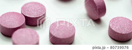 Purple pills scattered on a white background, food supplements which includes acai berries Purple pills scattered on a white background, food supplements which includes acai berries 80739076