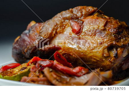 Bacon joint with bone served with grilled vegetables, red and yellow peppers, zucchini and red onion 80739705