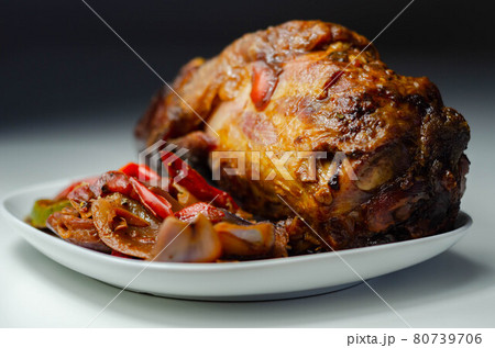 Bacon joint with bone served with grilled vegetables, red and yellow peppers, zucchini and red onion 80739706