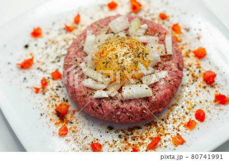 Beef steak tartare with raw egg yolk and onion with tomato 80741991