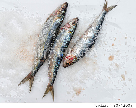Raw mackerel fish with sea salt on white ceramic surface Raw mackerel fish with sea salt on white ceramic surface 80742005