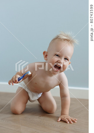 little boy brushes his teeth with a toothbrush and laughs 80743599