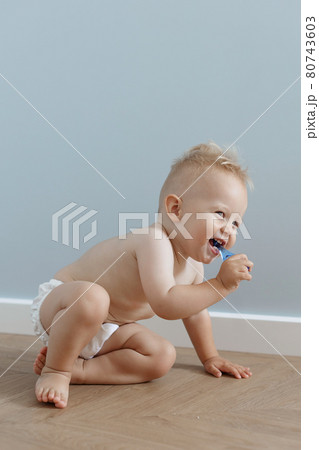 little boy brushes his teeth with a toothbrush and laughs 80743603