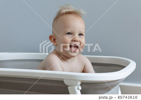 little boy is sitting in a bath and laughing 80743610