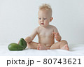 little boy holds avocado in his hands and smiles. 80743621