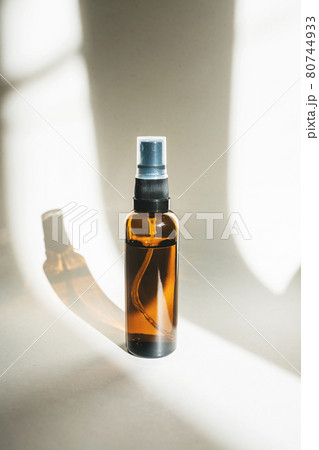Cosmetic bottle made of dark amber glass on a white background with a shadow. Cosmetic bottle made of dark amber glass on a white background with a shadow. 80744933