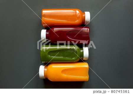 Fresh juices or smoothies of fruits and vegetables in bottles on a gray background. Flat Ley, top view. Fresh juices or smoothies of fruits and vegetables in bottles on a gray background. Flat Ley, top view. 80745361