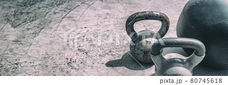 Gym fitness center header background panorama banner. Free weights kettlebell and medicine ball for training workout texture. Kettlebells heavy weight for weightlifting cross training panoramic 80745618