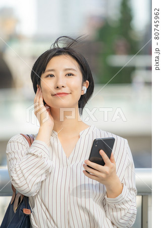 ワイヤレスイヤホンをするビジネスウーマン 80745962