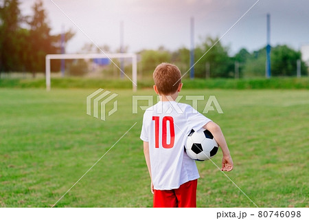 8 years old boy child holding football ball on playing field. 8 years old boy child holding football ball on playing field. 80746098