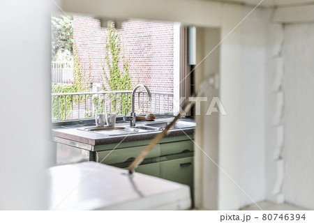 Sink with shiny tap installed under modern counter near jar with spices and gas stove in kitchen at home Sink with shiny tap installed under modern counter near jar with spices and gas stove in kitchen at home 80746394