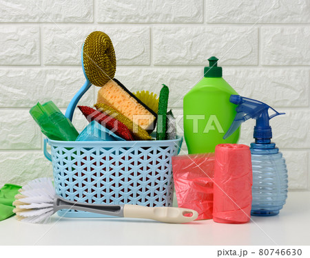 plastic basket with brushes, disinfectant in a bottle, rubber gloves on the background of a white brick wall plastic basket with brushes, disinfectant in a bottle, rubber gloves on the background of a white brick wall 80746630