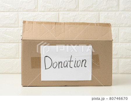 brown cardboard box with a pasted white sheet and the inscription donation on a white background 80746670