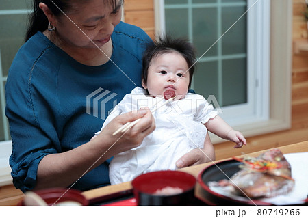 孫のお食い初めを執り行うシニアのお婆ちゃん 80749266