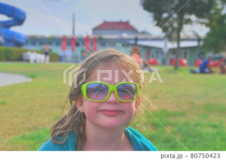 Happy kid at aqua. Little girl in sunglasses on a summer sunny day. Summer holiday concept Happy kid at aqua. Little girl in sunglasses on a summer sunny day. Summer holiday concept 80750423