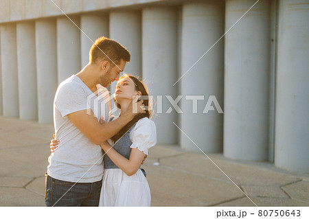 Medium shot portrait of happy romantic young couple in love hugging while man touching neck of girlfriends with hand Medium shot portrait of happy romantic young couple in love hugging while man touching neck of girlfriends with hand 80750643
