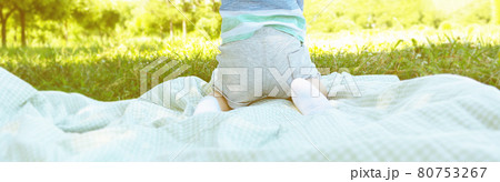 Boy sitting on blanket on grass. Picnic. 80753267