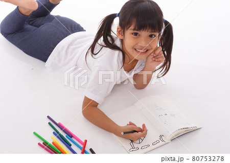 Cute little girl doing homework, reading a book, coloring pages, writing and painting. Children paint. Kids draw. Preschooler with books at home. 80753278