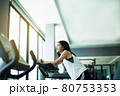 Fit young girl using exercise bike at the gym. Fitness female using air bike at gym. 80753353