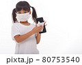 Asian girl wear mask cleaning smartphone screen with alcohol.on white background. Concept of Cleaning dirty screen phone for disease prevention from bacteria. 80753540