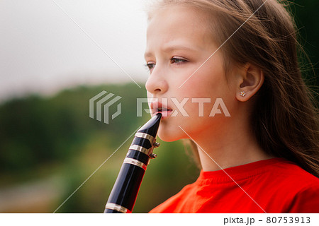 Young attractive girl playing clarinet, ebony in fall park Young attractive girl playing clarinet, ebony in fall park 80753913