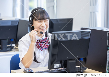 ヘッドセットをつけてパソコンを見る女子学生　撮影協力：中央工学校附属日本語学校 80754225