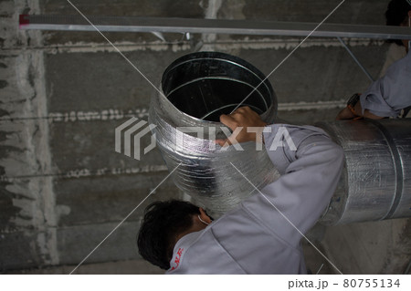 worker install air ventilation duct pipes on ceiling 80755134