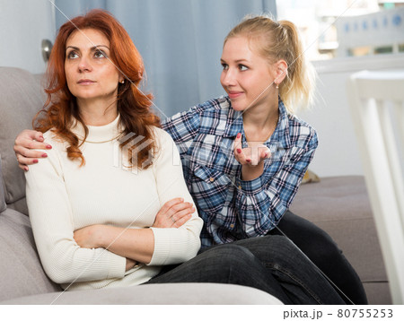 Upset woman looking away after conflict, teen daughter tries reconcile 80755253