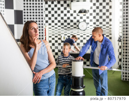 Brooding family trying to find a solution to a puzzle in the quest room 80757970