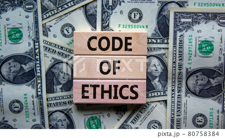 Concept text 'code of ethics' on wooden blocks on a beautiful background from dollar bills. Concept text 'code of ethics' on wooden blocks on a beautiful background from dollar bills. 80758384