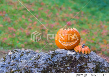 Scary smiling face halloween pumpkin on a stone 80758917