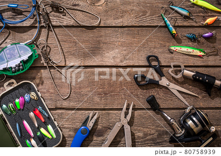 Fishing tackle - fishing spinning, fishing line, hooks and lures on wooden background. 80758939