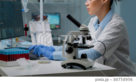 Close up of microscope tool while scientist analyzing petri dish 80758956