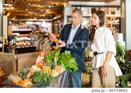 Couple choosing bottle of wine in supermarket Couple choosing bottle of wine in supermarket 80759662