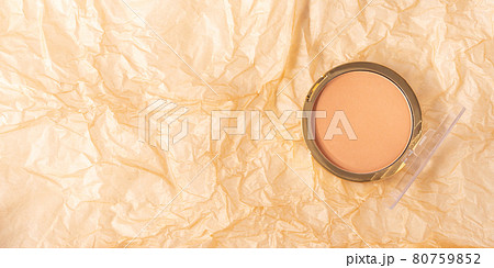 Compact face powder on crumpled beige textured background Compact face powder on crumpled beige textured background 80759852
