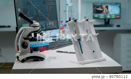 Scientific micropipette and microscope in laboratory 80760112