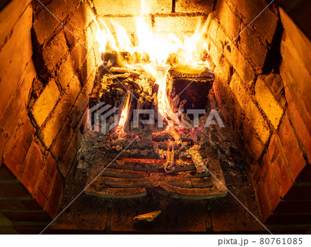 grate and burning firewood in hearth 80761085